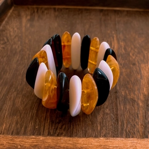 Detailed close-up of acrylic block stretch bracelet on a vintage wood surface