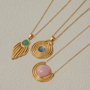 Makroansicht von Vintage Goldketten mit blauen, grünen und rosa Edelsteinen im Detail