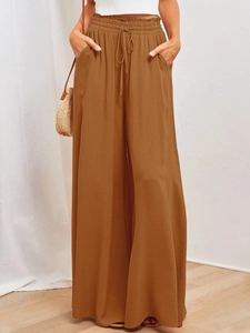 Détail d'un pantalon large en lin à taille haute avec cordon de serrage et poches