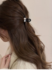 Gros plan d'une mini pince à cheveux en perles sur des cheveux ondulés pour un look élégant