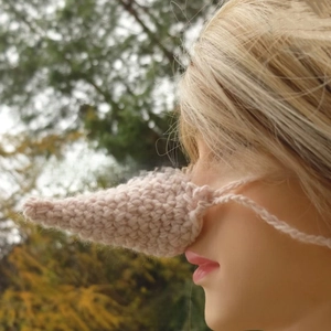 Detail view of handmade pink knit nose warmer on a mannequin with crochet texture