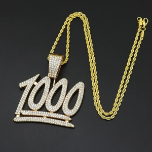 Détail d'un collier hip hop doré avec pendentif 1000 serti de diamants et couronne