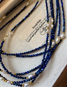 Vue détaillée de perles d'eau douce et lapis-lazuli bleu avec des accents dorés