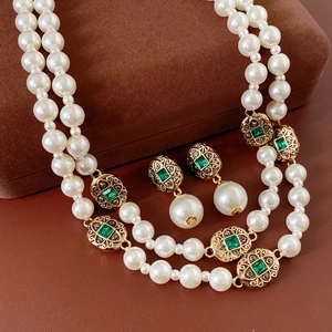 Dettaglio della collana vintage di perle a doppio strato con gemme verdi e oro floreale