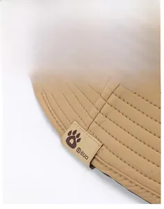 Close-up of khaki sun hat featuring multi-row stitching on brim and logo woven label