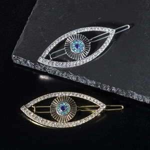 Detail of gold and silver eye-shaped hair clips with sparkling rhinestone inlay