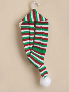 Detail of red and green striped knit dog scarf with soft white pompom and texture