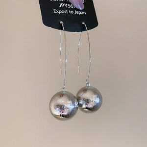 Macro detail of silver 925 ball drop earring with a unique textured metallic finish