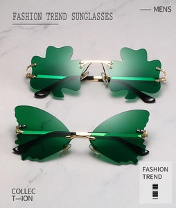 Close-up of green shamrock and butterfly sunglasses with gold metal frames on marble