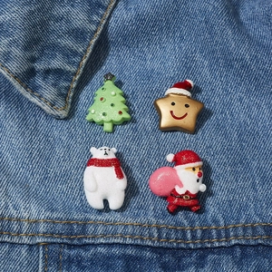Detailansicht von Acryl-Broschen mit Weihnachtsmann, Eisbär und Stern auf Jeansstoff