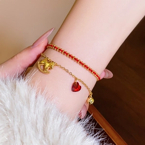 Bracelet double rang plaqué or 18 carats avec pendentif cheval et corde rouge sur poignet