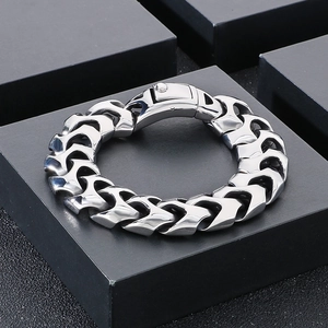 Polished silver punk style dragon bone chain bracelet on black textured jewelry box