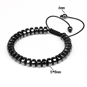 Macro detail of hematite disk beads and adjustable cord on a men's energy bracelet