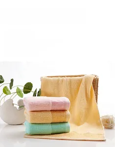 Close-up of pastel cotton towels showing geometric embossed pattern and soft texture