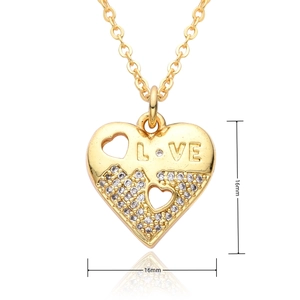 Detailed macro view of gold heart pendant with LOVE engraving and cubic zirconia stones