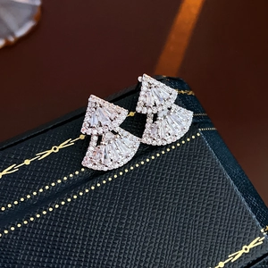 Macro view of silver layered fan-shaped earrings with sparkling cubic zirconia inlay