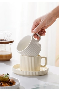 Detailed view of fluted ceramic coffee cup and saucer set with matte finish texture