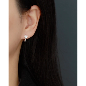 Close-up of elegant s925 silver heart-shaped zircon huggie earrings worn on model ear
