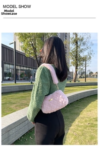 Detail view of a pink plush shoulder bag with quilted pattern and golden metal plate