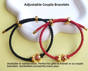 Close-up of adjustable woven couple bracelets with golden fish charms in red and black