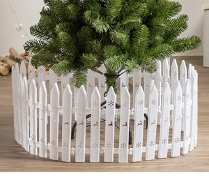 Close-up of white plastic picket fence with hollow snowflake and deer patterns for Christmas