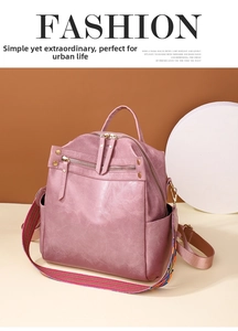 Close-up of pink PU leather backpack with lychee texture and striped woven strap
