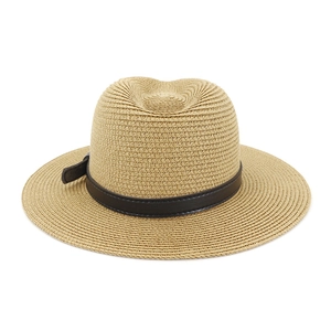 Detail of a woven straw fedora featuring a dark brown leather band and adjustable buckle
