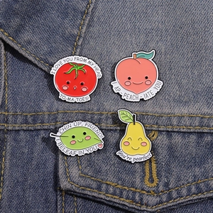 Set of four cute fruit enamel pins on denim jacket including strawberry and peach designs