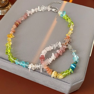 Close-up of colorful natural stone beaded necklace with metal lobster clasp on velvet