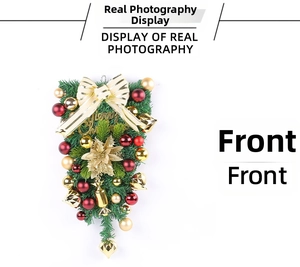 Macro detail of Christmas teardrop swag with gold bow and festive red ornaments