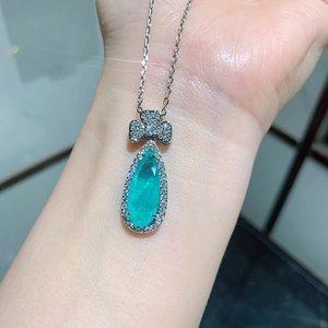 Makroaufnahme von birnenförmigem Smaragdanhänger mit silbernen Mikro-Pave-Diamanten