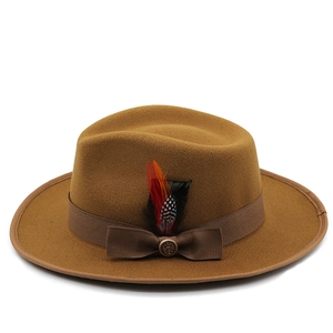 Detail of tan wool fedora featuring a grosgrain band, metal anchor buckle, and real feathers
