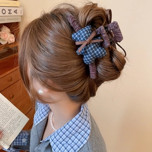 Detail of fabric teddy bear hair claw clip with blue plaid dress worn in a side bun
