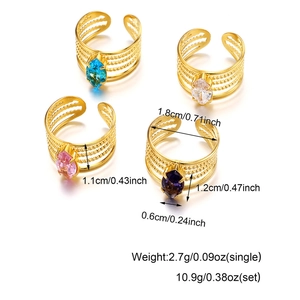 Detail of four gold plated stainless steel rings featuring colorful marquise-cut zircons