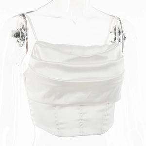 Detail of white satin cowl neck top with corset seams and glossy draped fabric finish