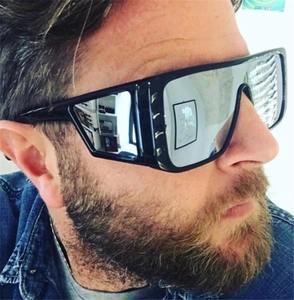 Side view of trendy oversized sunglasses with black frame and silver mirrored lenses on male