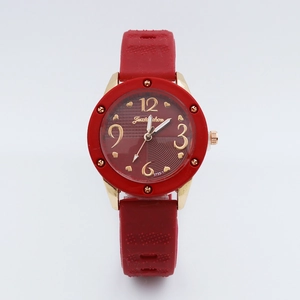 Detailed macro view of red silicone watch strap and golden case with red heart dial
