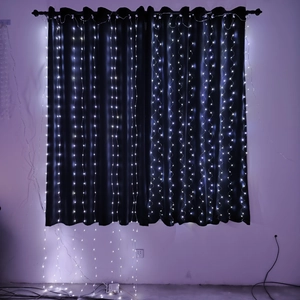 Detail view of white LED curtain lights hanging against black drapes for home decoration