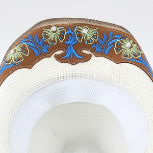 Vue détaillée d'un chapeau de cowboy blanc avec broderie florale et strass brillants