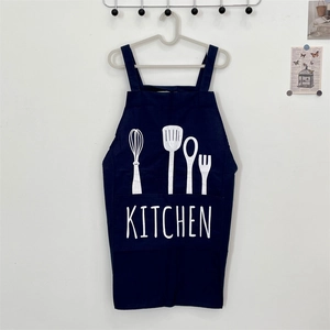 Close-up of deep blue kitchen apron with white utensil illustrations and large pocket