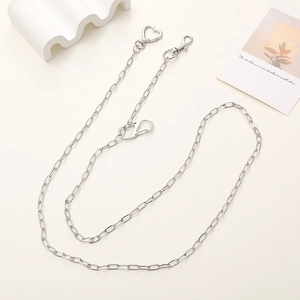 Close-up of polished silver metal bag chain featuring heart-shaped lobster clasps