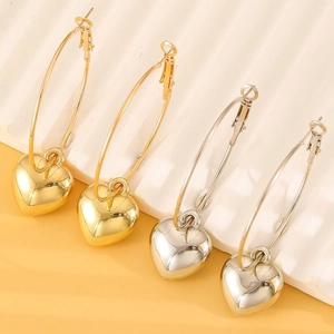 Detailed view of polished gold and silver hoop earrings with 3D heart-shaped pendants