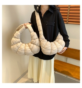 Detail view of cream quilted bubble bag showing pleated texture and crossbody strap