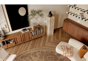 Artistic round rug with vintage floral patterns on a herringbone wood floor