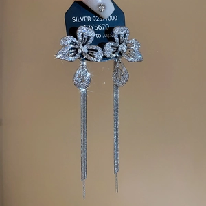 Macro shot of silver flower earrings with tassels and S925 silver stamp on jewelry card