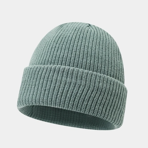 Detail view of the thick ribbed knit texture on a grey-green winter beanie hat