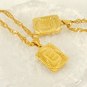Gold initial letter pendant necklace featuring engraved rectangular charms F and E