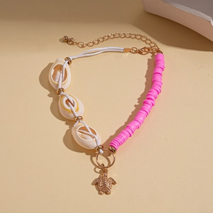 Detail of beaded sea turtle bracelet with pink heishi beads and natural shells