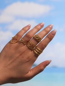 Close-up of golden stainless steel geometric wheat ear rings set on model hand