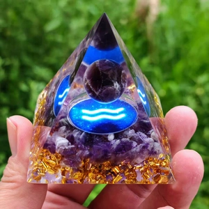 Orgone pyramid with amethyst crystals, gold foil, and glowing Aquarius symbol